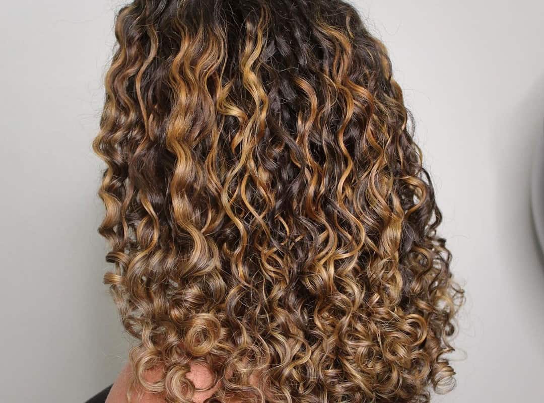 Honey balayage on curly dark brown hair