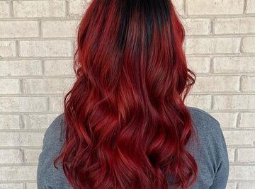 Red balayage hairstyle on black curly hair