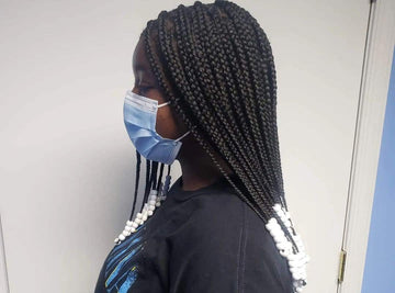 girl with black box tribal braids with white beads